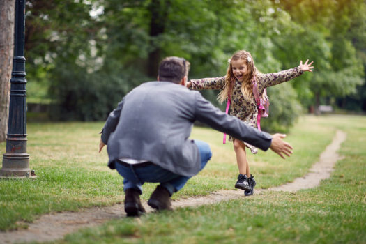 Schoolgirl running to greet her dad